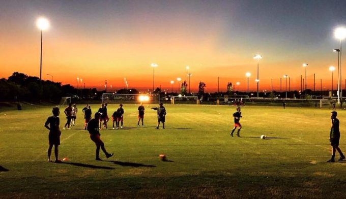 houston express players on a soccer field at dusk